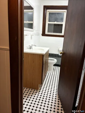a bathroom with a sink a toilet a mirror and shower