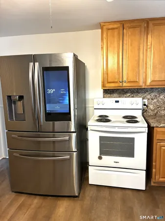 a kitchen with granite countertop white cabinets and stainless steel appliances