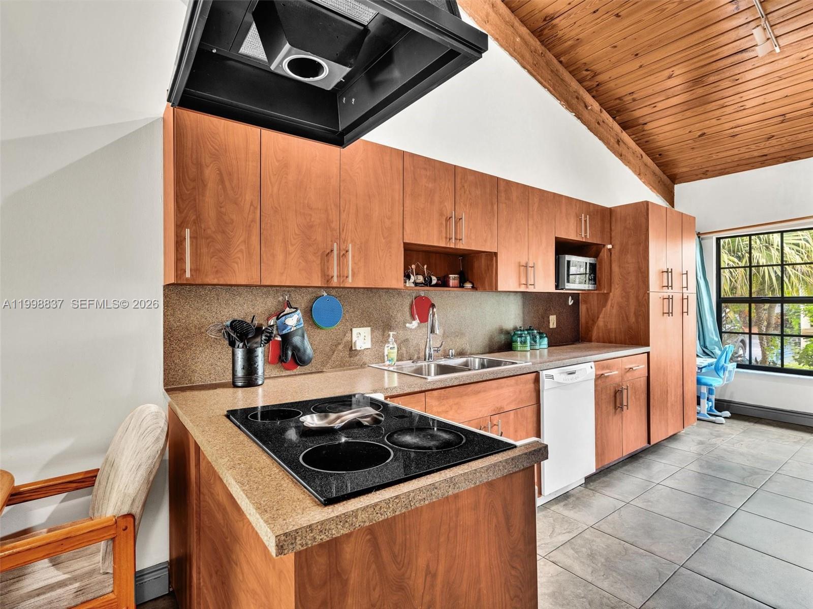 13406 Southwest 102nd Lane Miami, FL 33186 - Photo 12 of 47 a kitchen with stainless steel appliances a stove a sink and a microwave