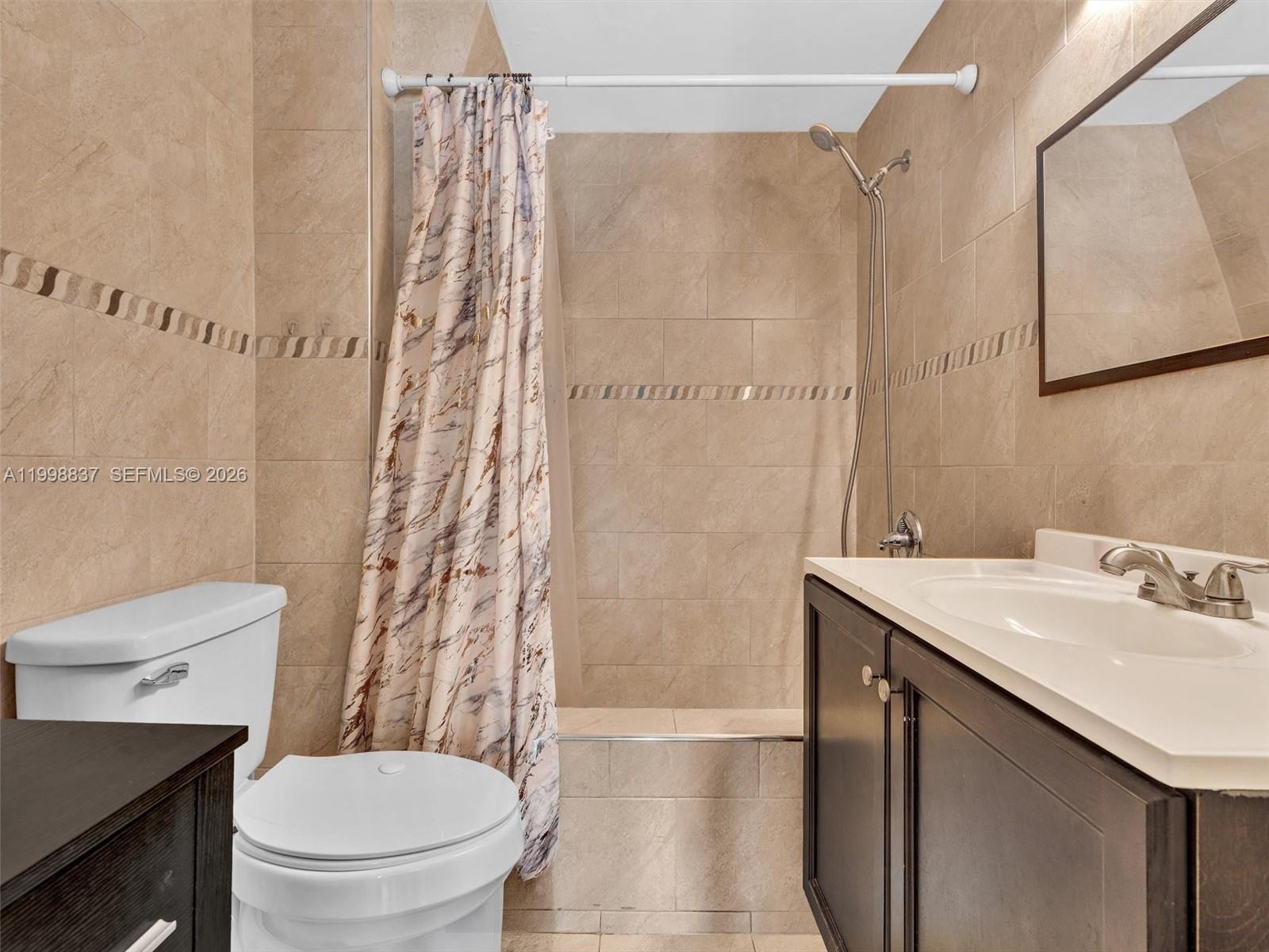 13406 Southwest 102nd Lane Miami, FL 33186 - Photo 25 of 47 a bathroom with a sink a toilet and shower curtain