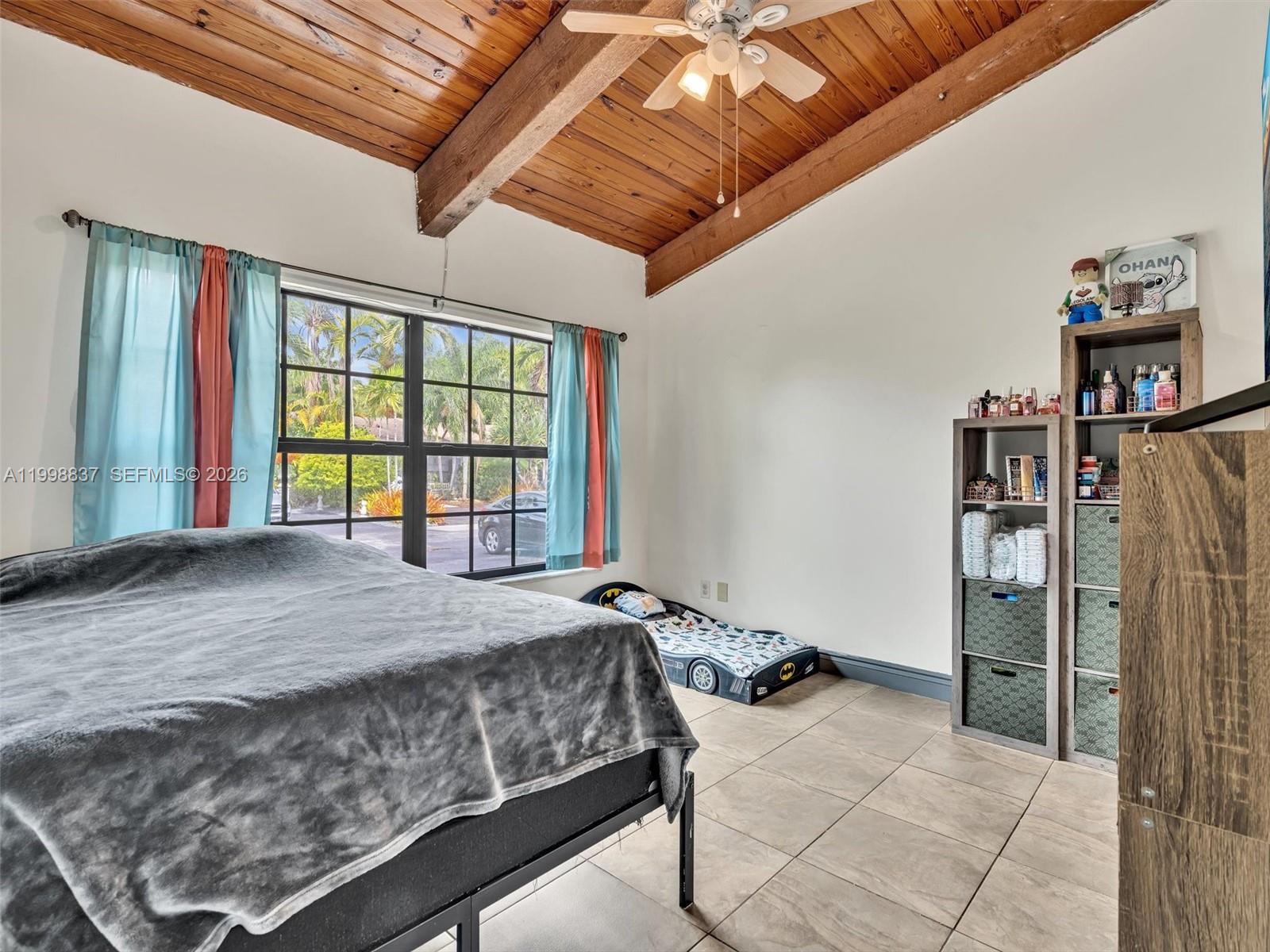 13406 Southwest 102nd Lane Miami, FL 33186 - Photo 29 of 47 a bed sitting in a bedroom next to a window