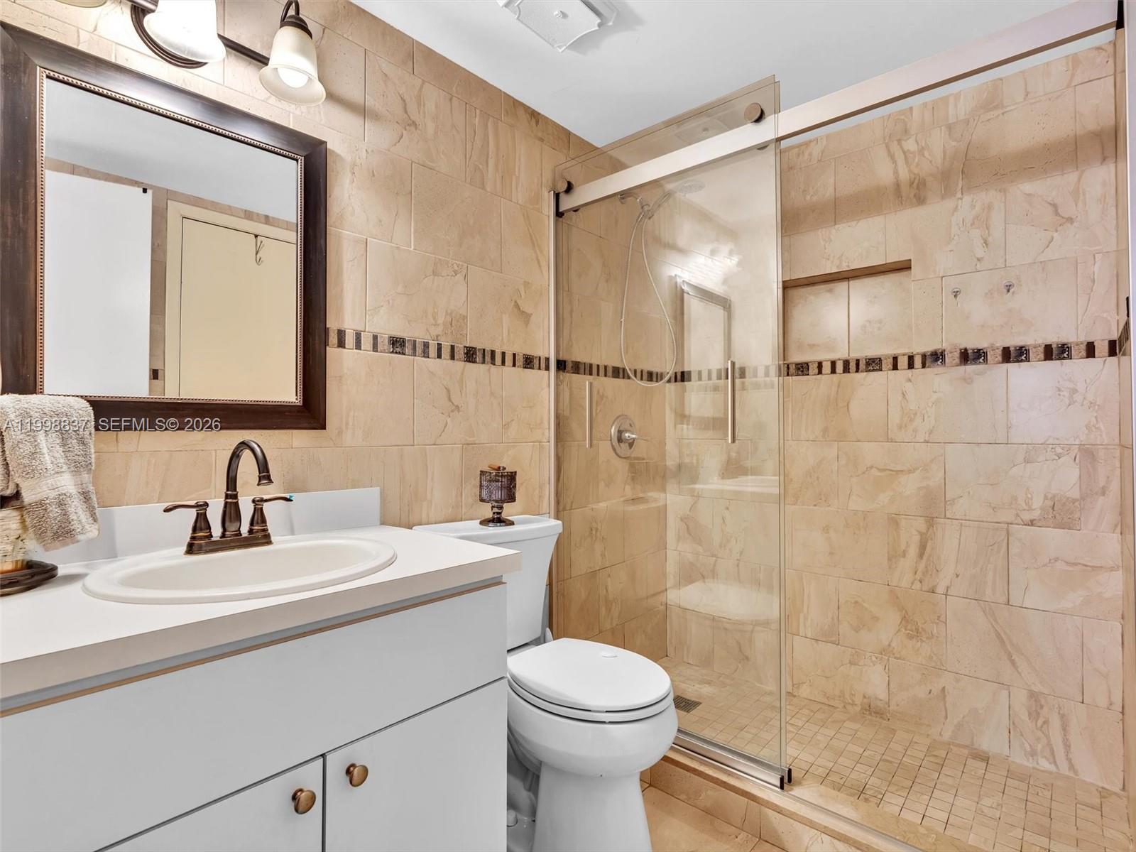 13406 Southwest 102nd Lane Miami, FL 33186 - Photo 32 of 47 a bathroom with a sink toilet a mirror and shower