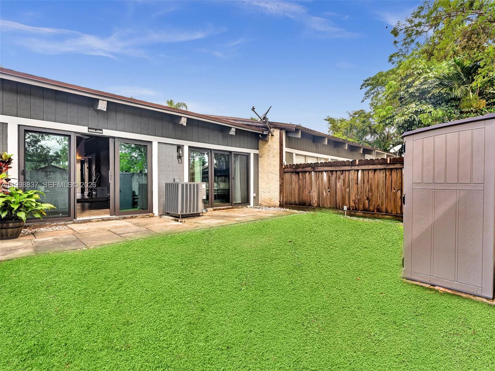 13406 Southwest 102nd Lane Miami, FL 33186 - Photo 35 of 47 a view of a backyard with table and chairs and wooden fence