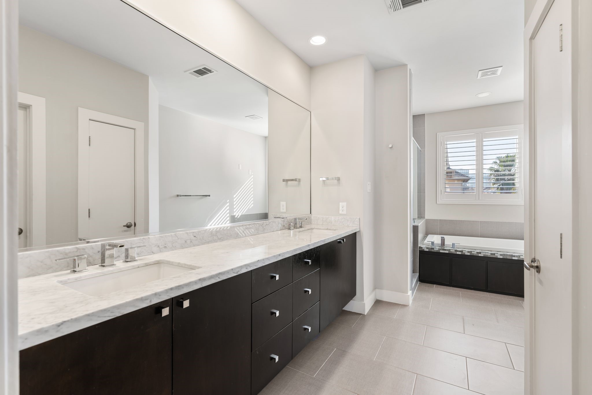 5911 Rose Street Houston, TX 77007 - Photo 17 of 40 Spa-like primary bath with double sinks, soaking tub, and separate shower—designed for comfort and relaxation.