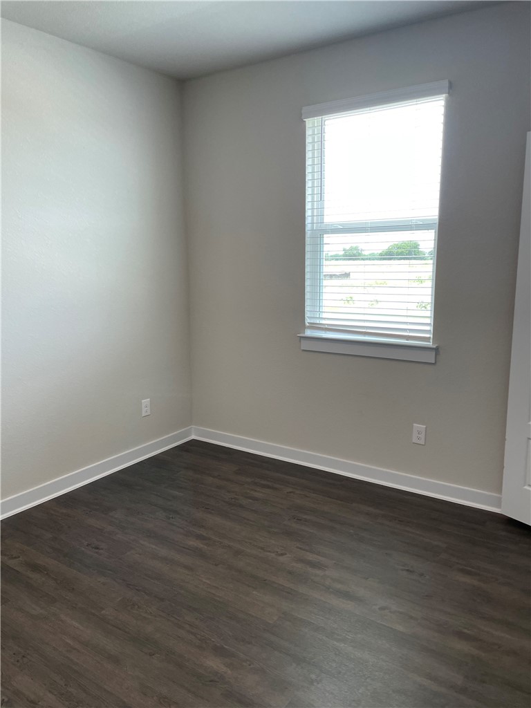 609 Paddock Lane Georgetown, TX 78626 - Photo 24 of 40 Rich dark wood flooring contrasts beautifully against smooth light walls and a bright window.