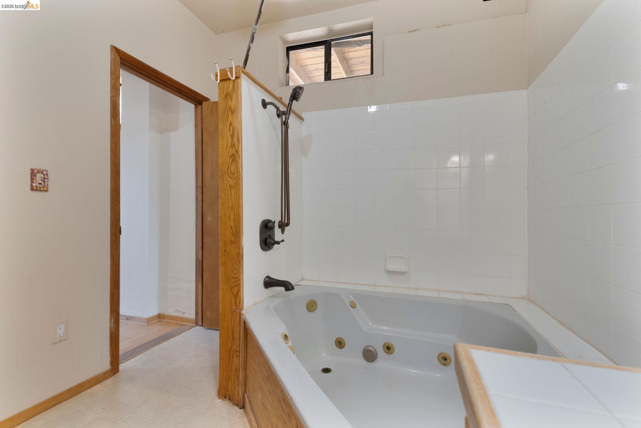 22963 Robertson Ranch Road Sonora, CA 95370 - Photo 42 of 90 Jetted tub with white tiled surround and dark bronze fixtures