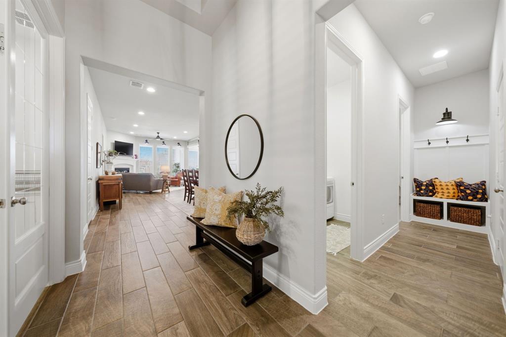 1121 Bantham Way Forney, TX 75126 - Photo 4 of 28 Wood-look ceramic tile flooring throughout with a convenient hall tree at the garage entry.