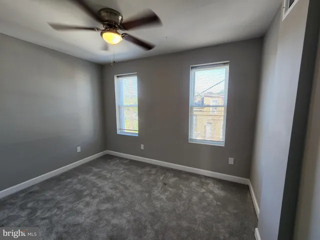 an empty room with a window and a fan