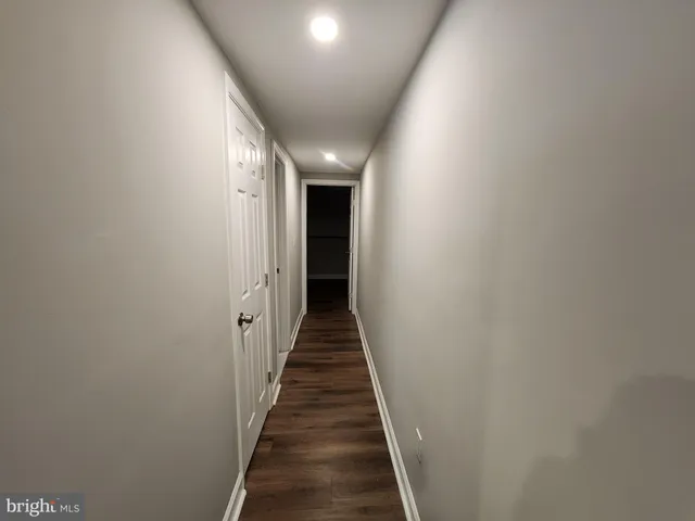 a view of a hallway with wooden floor and stairs