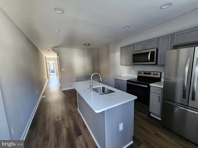 a kitchen with stainless steel appliances granite countertop a refrigerator a stove top oven a sink and dishwasher