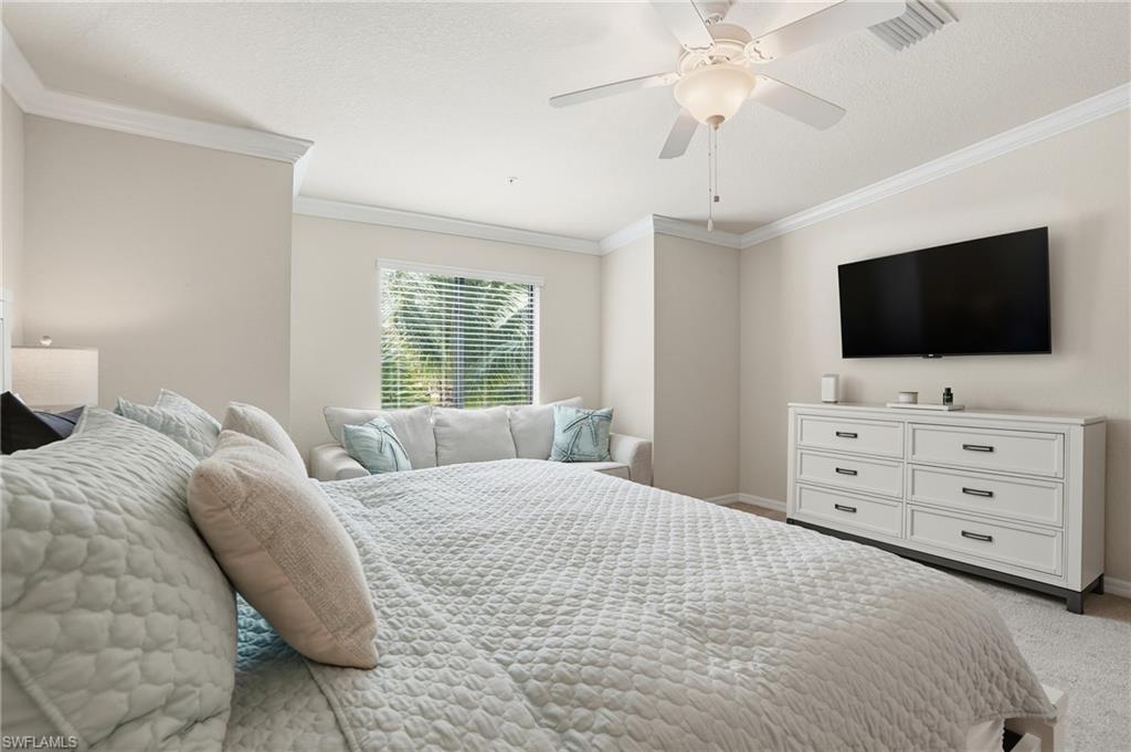 9528 Avellino Way, Unit 2521 Naples, FL 34113 - Photo 14 of 41 a large bedroom with a bed and a flat screen tv