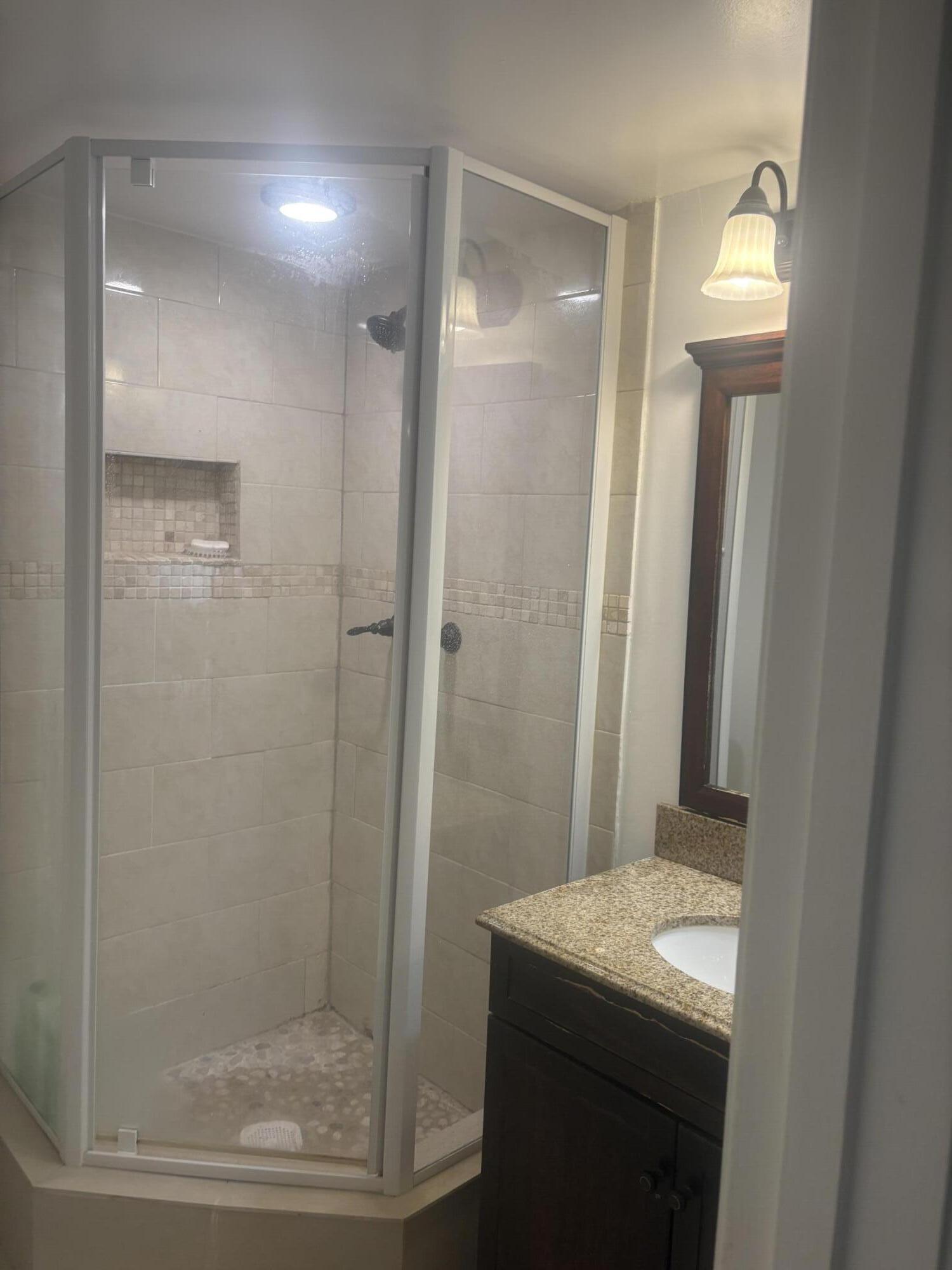 9355 Southwest 8th Street, Unit 225 Boca Raton, FL 33428 - Photo 15 of 21 a bathroom with a granite countertop sink a shower and a mirror