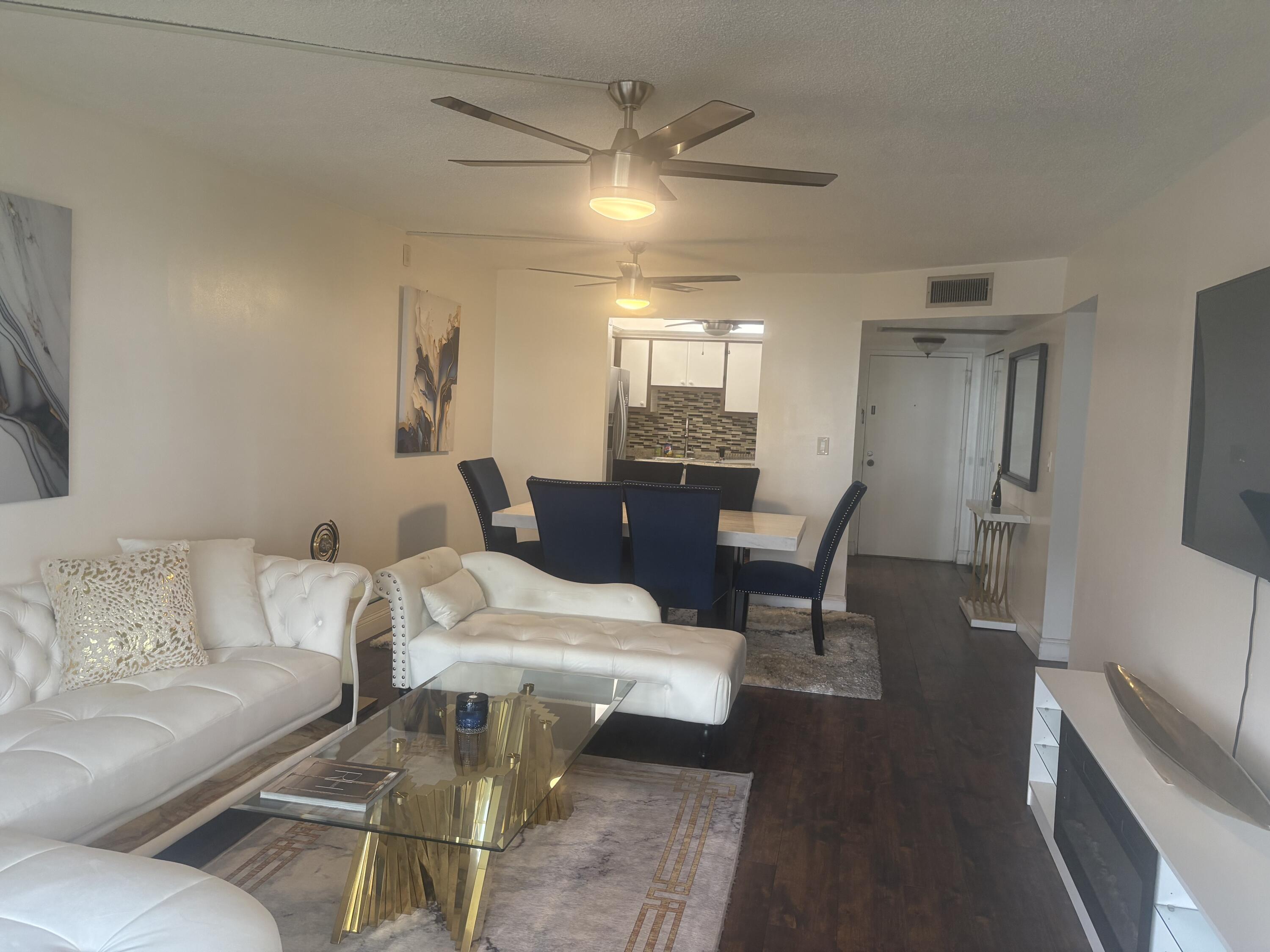 9355 Southwest 8th Street, Unit 225 Boca Raton, FL 33428 - Photo 4 of 21 a living room with furniture and a chandelier