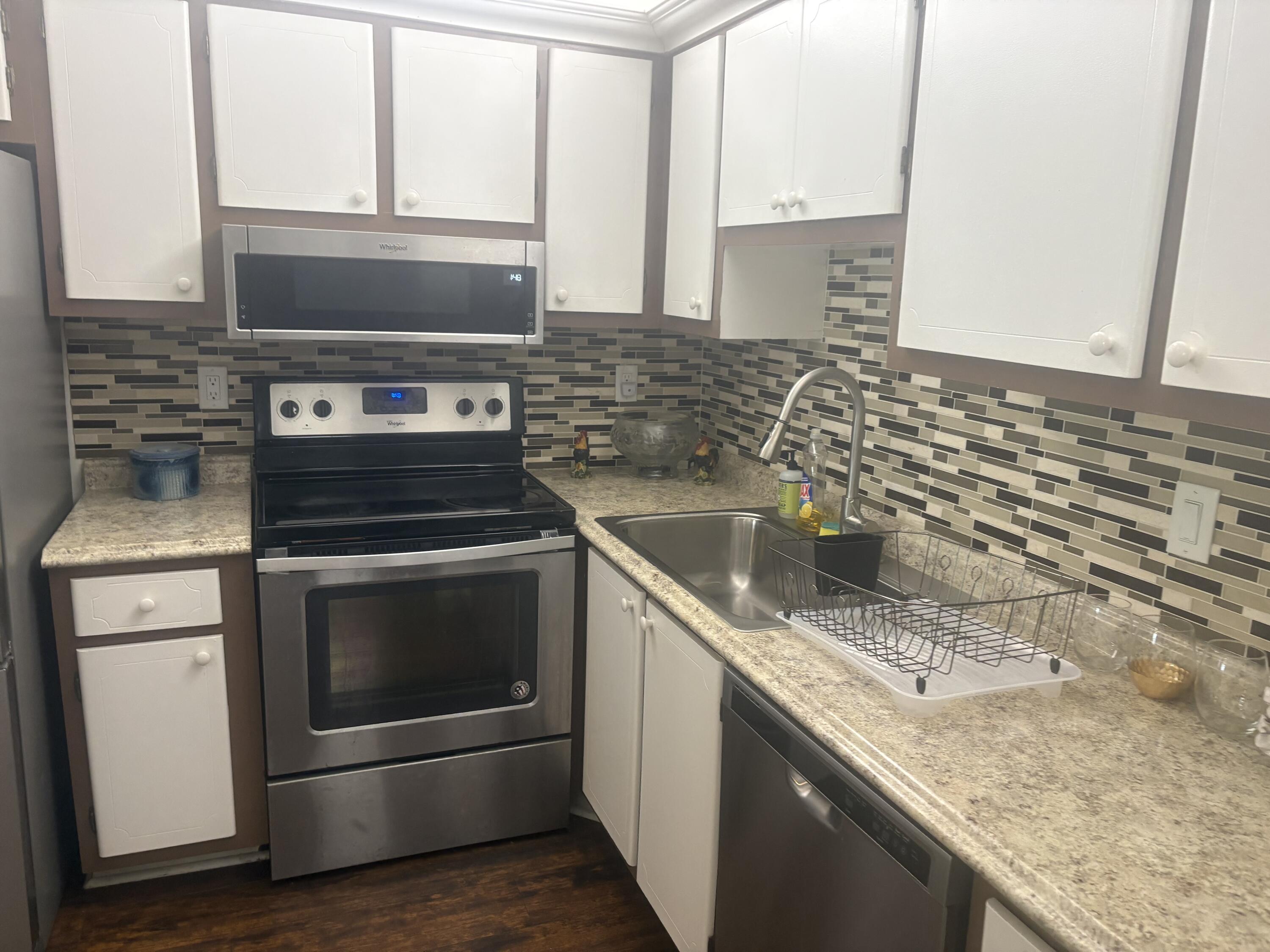 9355 Southwest 8th Street, Unit 225 Boca Raton, FL 33428 - Photo 8 of 21 a kitchen with granite countertop a stove and a microwave