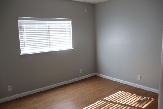 329 Lenore Street Ridgecrest, CA 93555 - Photo 12 of 28 an empty room with wooden floor and windows