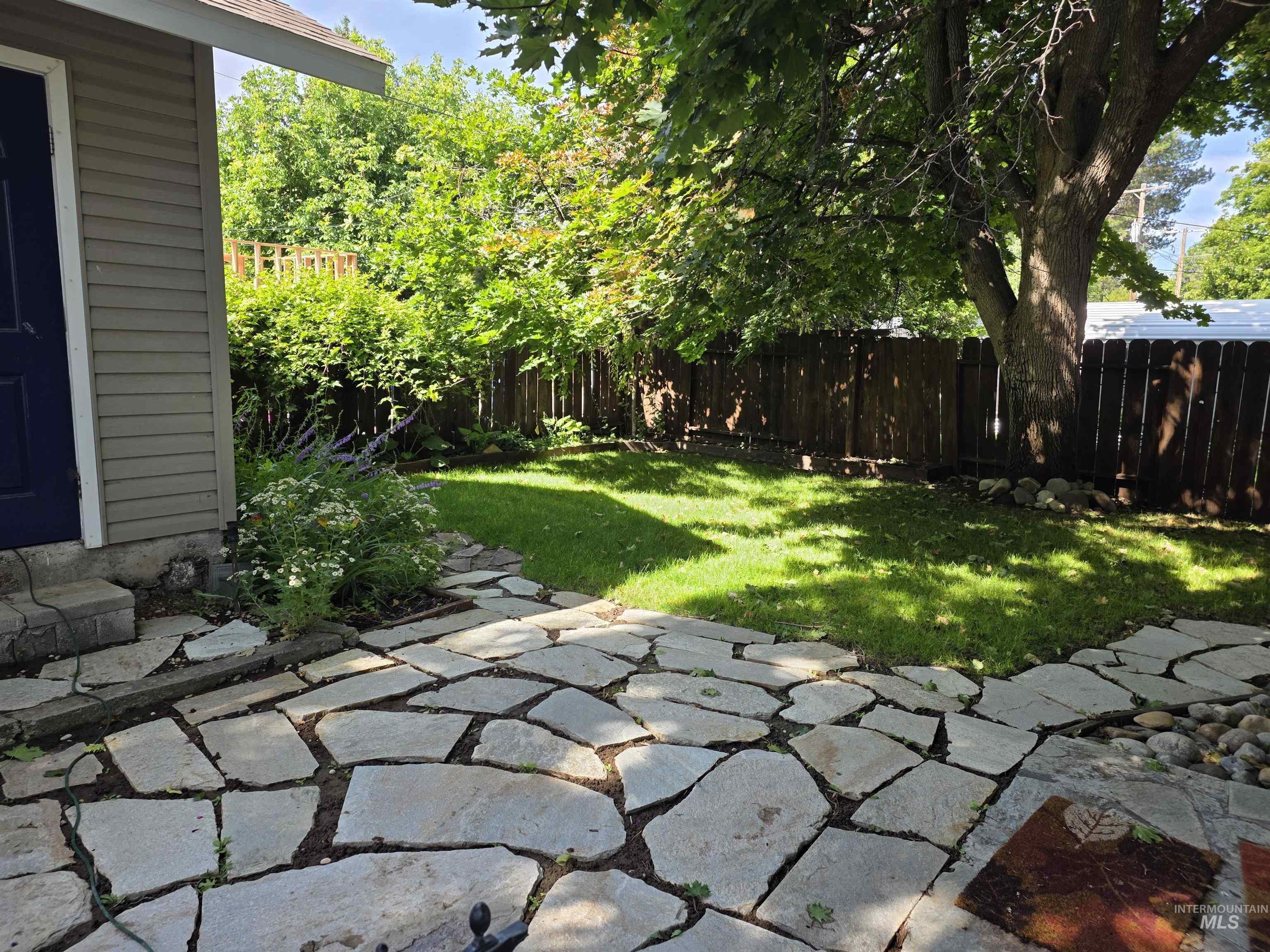 421 East Main Street Jerome, ID 83338 - Photo 3 of 13 Expansive backyard featuring a stone patio, manicured lawn, and mature trees