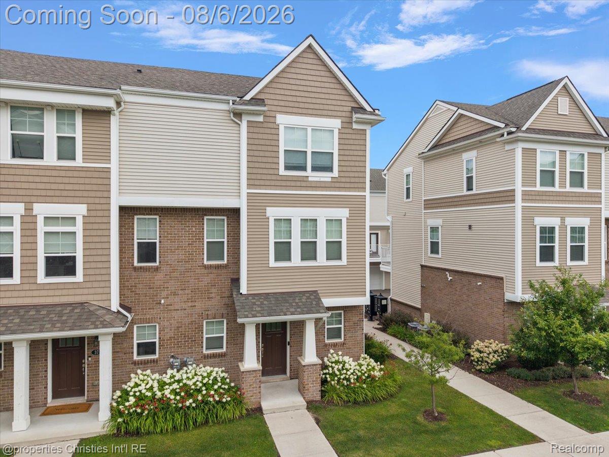 2500 Normandy Road, Unit 38 Royal Oak, MI 48073 - Photo 42 of 55 Multi-level townhome featuring a brick and siding exterior, gabled rooflines, white window trim, and a covered entry with columns