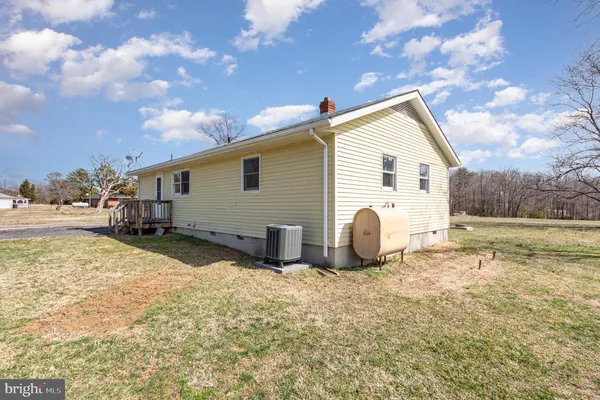 a view of a house with backyard and a tree