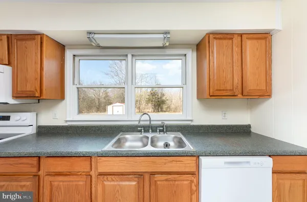 a kitchen with stainless steel appliances granite countertop a sink a cabinets and a counter space
