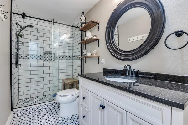 a bathroom with a sink a toilet and a mirror