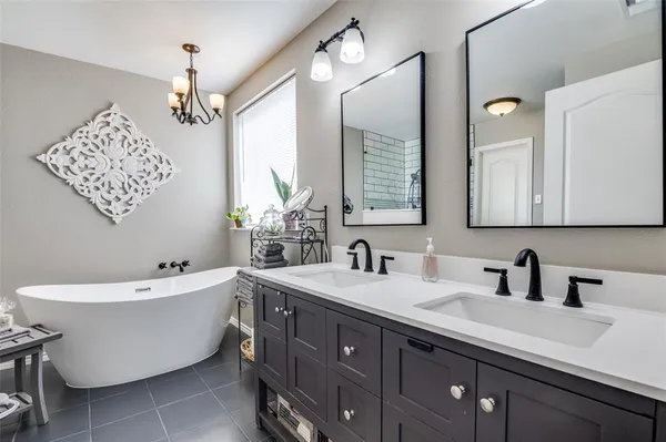 a bathroom with a double vanity sink mirror and bathtub