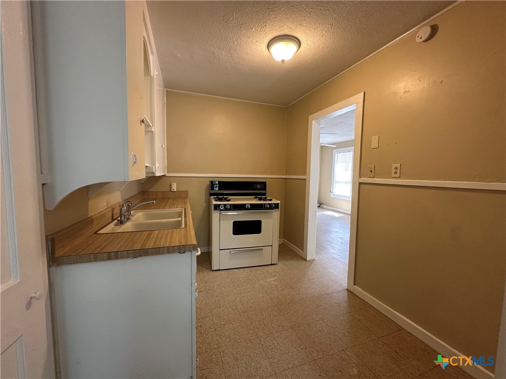 908 Pecan Street Seguin, TX 78155 - Photo 6 of 11 a kitchen with a refrigerator and a stove