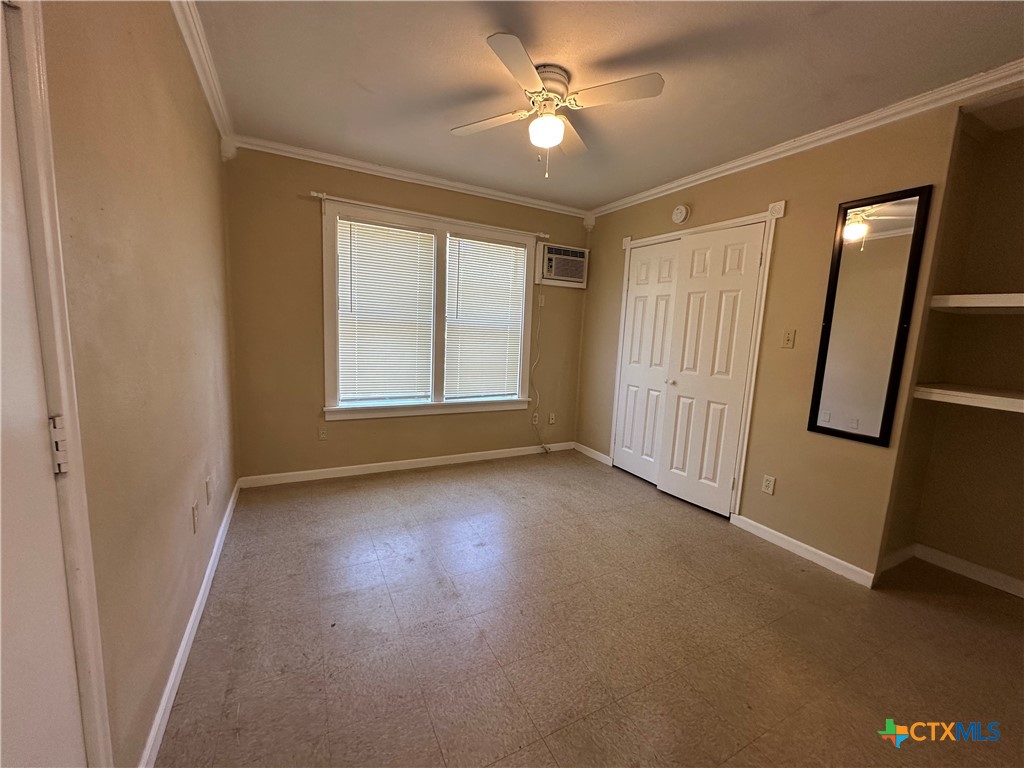 908 Pecan Street Seguin, TX 78155 - Photo 9 of 11 an empty room with windows and fan