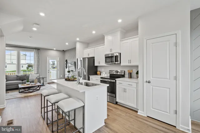 a large white kitchen with stainless steel appliances