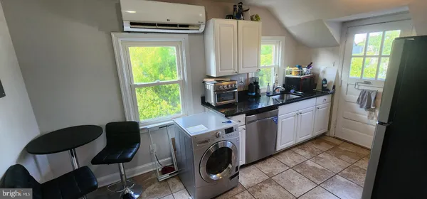 a view of a kitchen with fridge and workspace