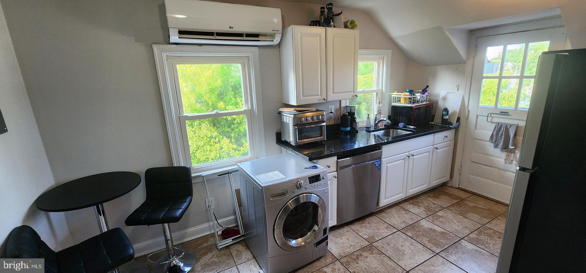 a view of a kitchen with fridge and workspace