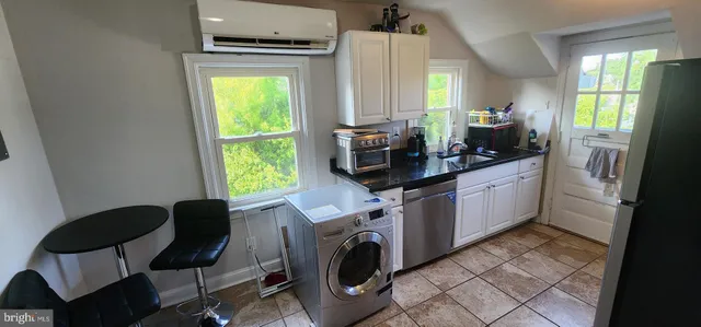a view of a kitchen with fridge and workspace