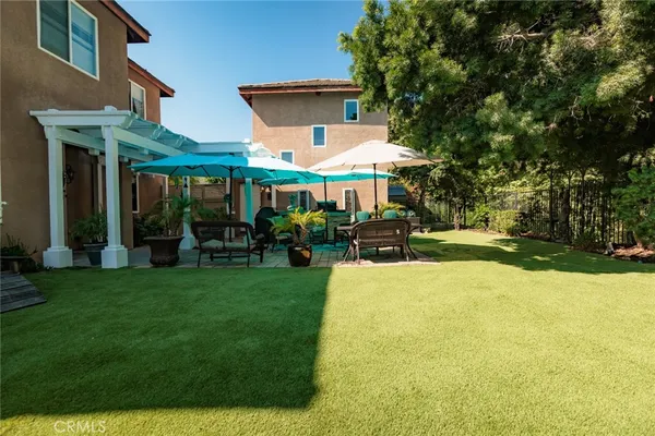 a view of a house with a big yard potted plants and large tree