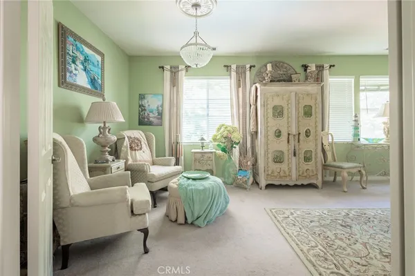 a living room with furniture a chandelier and a window