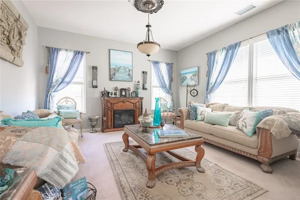 a living room with furniture a fireplace and a chandelier