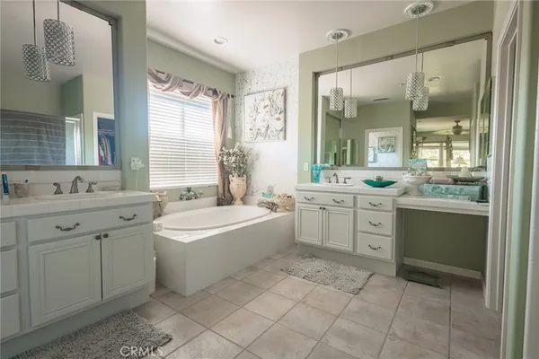a bathroom with a granite countertop sink mirror bathtub and double