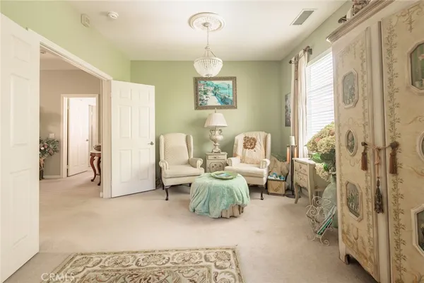 a living room with furniture chandelier and a rug