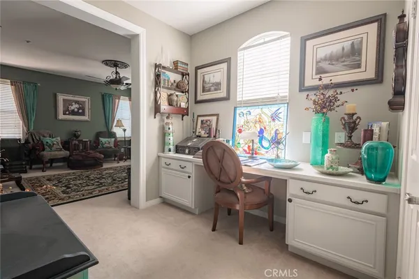 a view of a workspace with furniture and a window