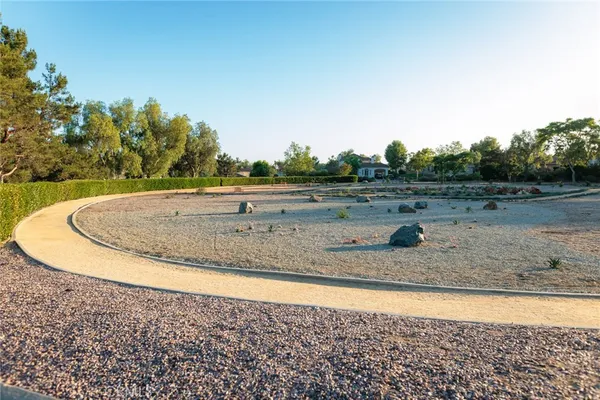 a view of a dry yard with wooden fence