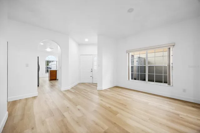 a view of an empty room with a window and a kitchen