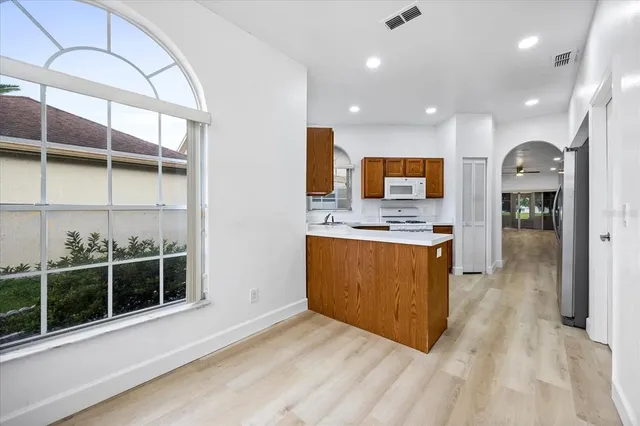 a view of kitchen with stainless steel appliances granite countertop a stove a sink and a refrigerator