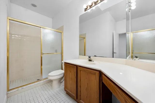 a bathroom with a sink a toilet a mirror and shower