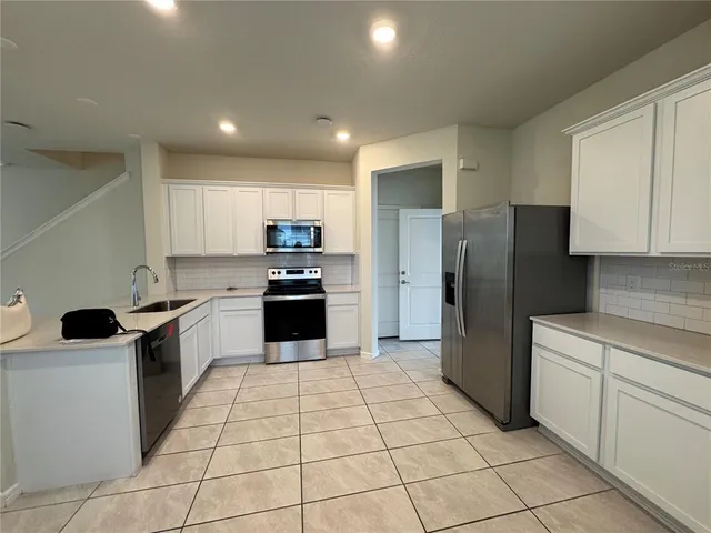 a kitchen with stainless steel appliances granite countertop a refrigerator and a stove top oven