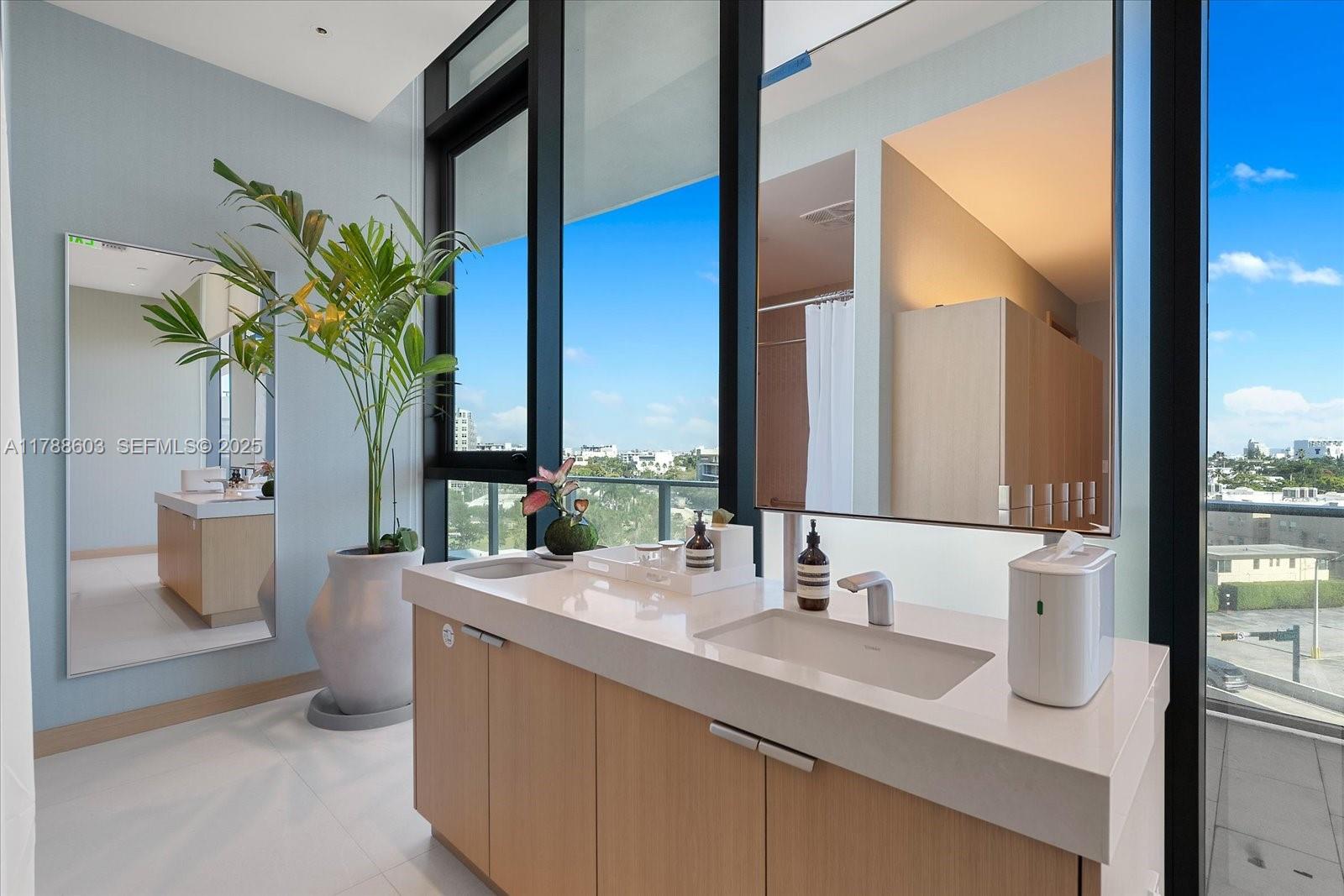 500 Alton Road, Unit 1105 Miami Beach, FL 33139 - Photo 37 of 69 a bathroom with a sink a mirror and a potted plant