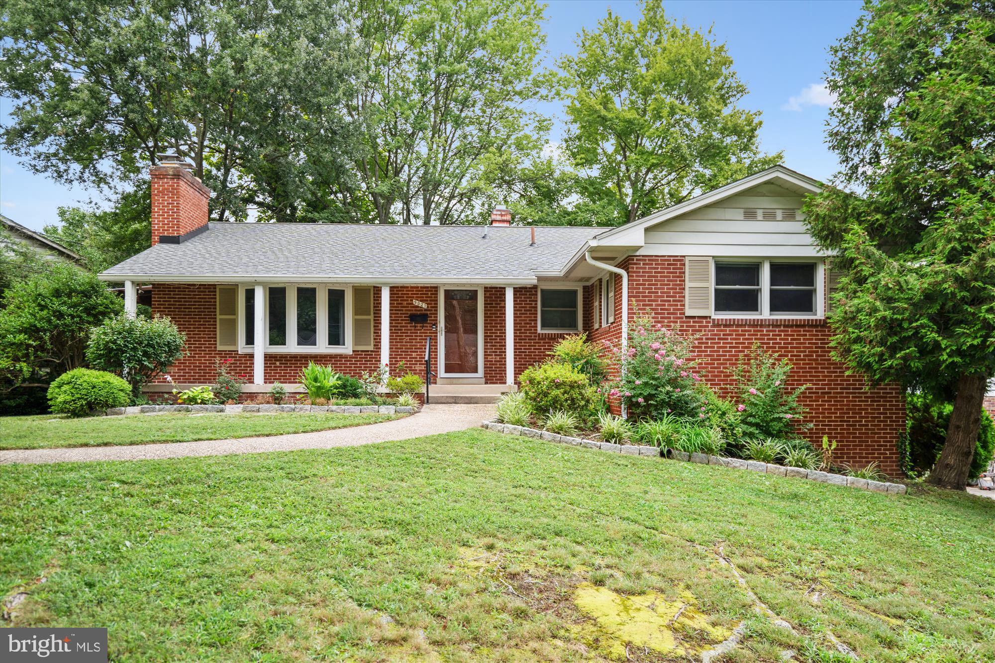 a front view of a house with yard and green space