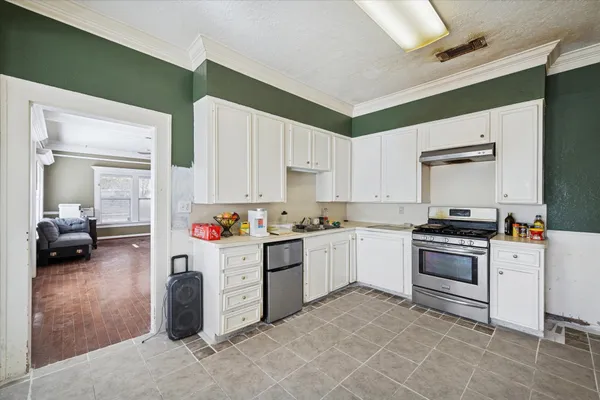 a kitchen with a stove and white cabinets