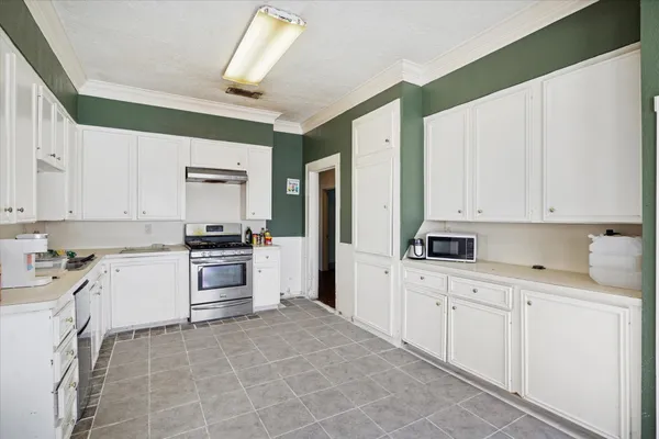 a kitchen with white cabinets and white appliances