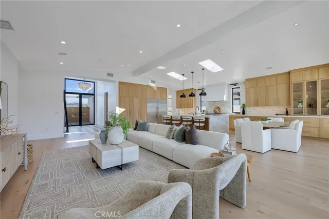 a living room with furniture kitchen view and a large window
