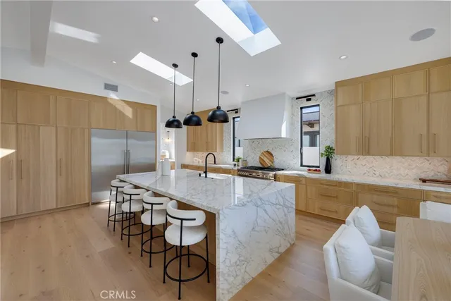 a kitchen with stainless steel appliances granite countertop a kitchen island a stove and a sink