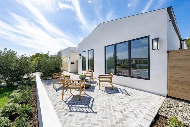a view of a patio with couches table and chairs and potted plants