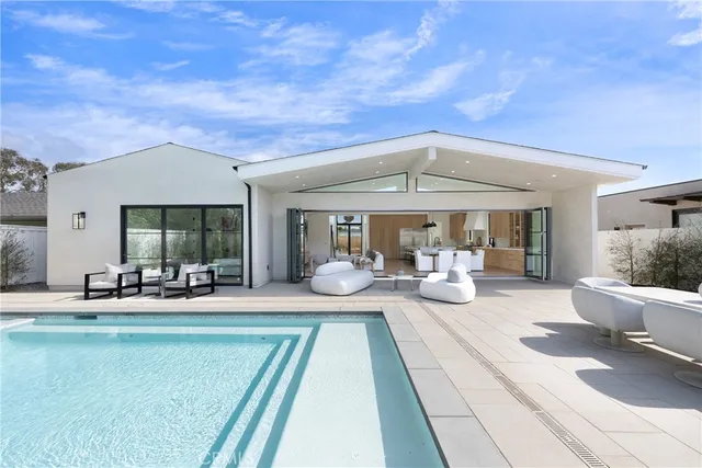 a view of a patio with couches table and chairs with potted plants and large tree